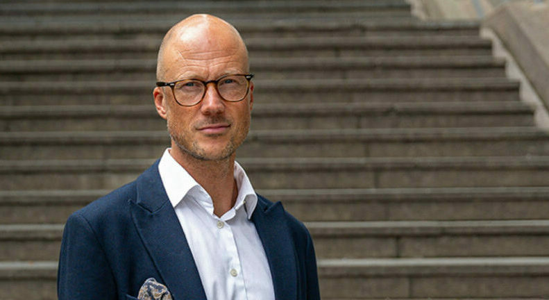 Man i kostym står framför en trappa, representerande investeringsåret 2024.