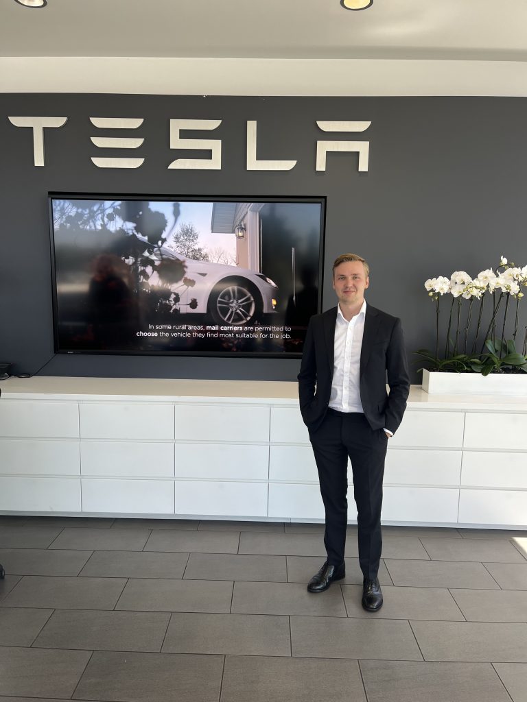 Herman Olsson framför Tesla skylt